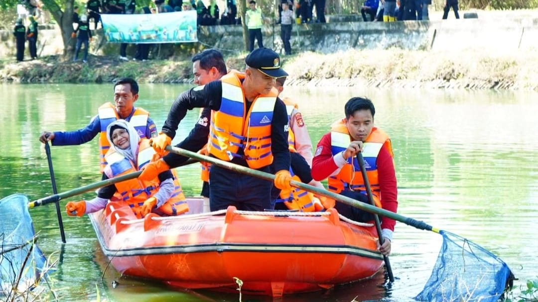 Pj Sekda Prabumulih Naik Perahu Karet, Bersihkan Sampah di Kolam Retensi